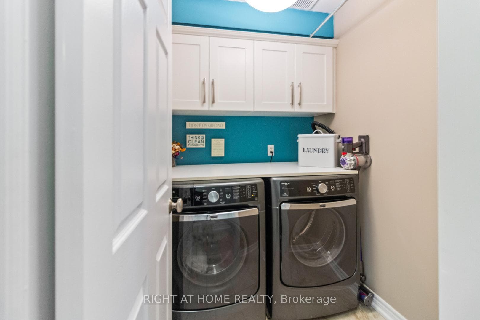 Main floor laundry with storage cabinets
