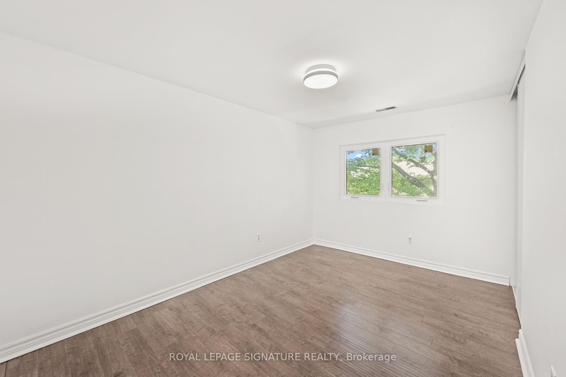 Third bedroom with window overlooking backyard