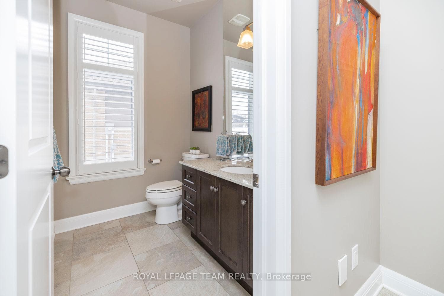 Bright powder room with granite vanity & window.